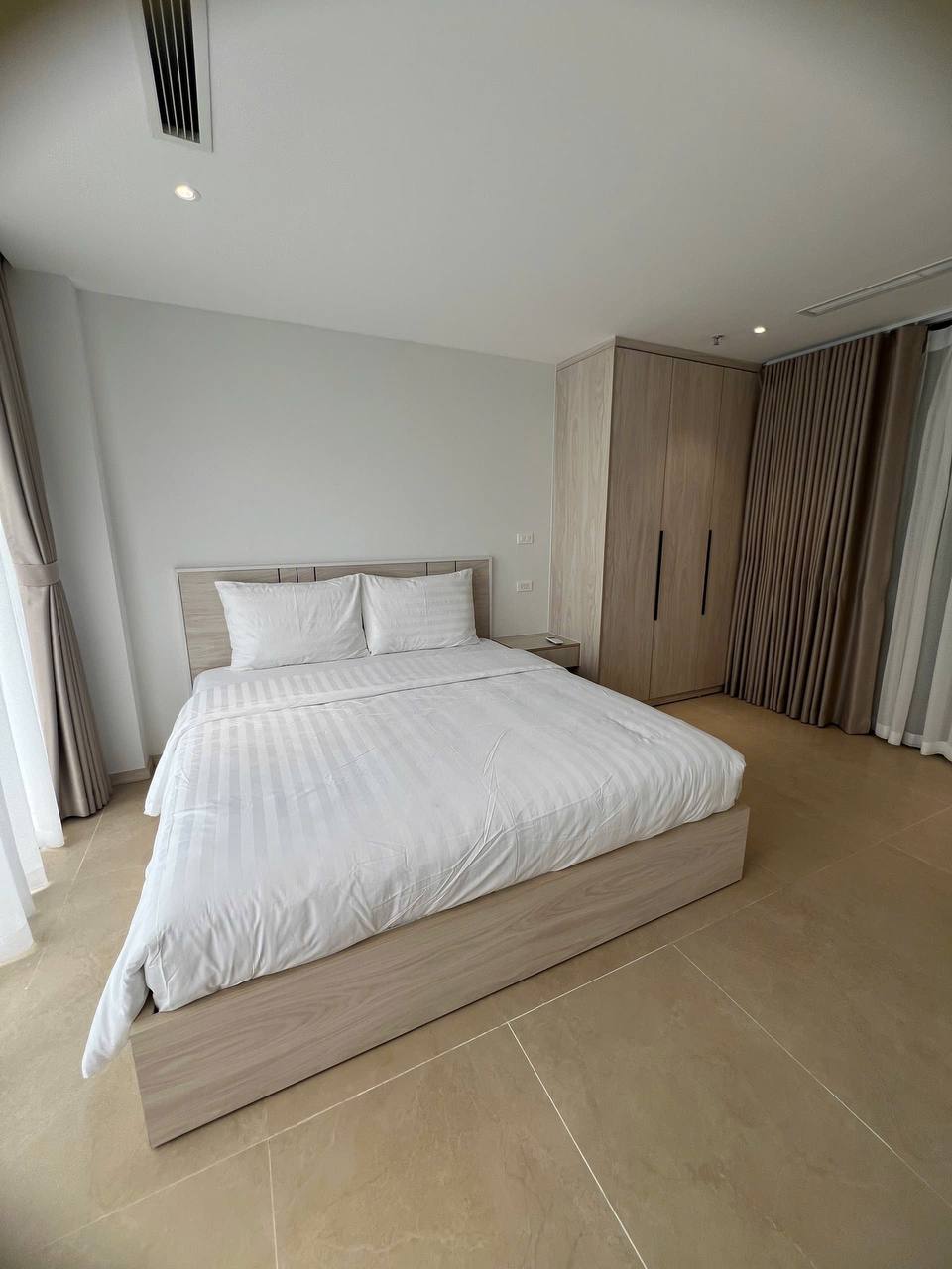 Toàn cảnh căn hộ studio homestay 157 Nhật Chiêu - giường đôi, bếp mini, bàn ăn, tone trắng kem gỗ sáng