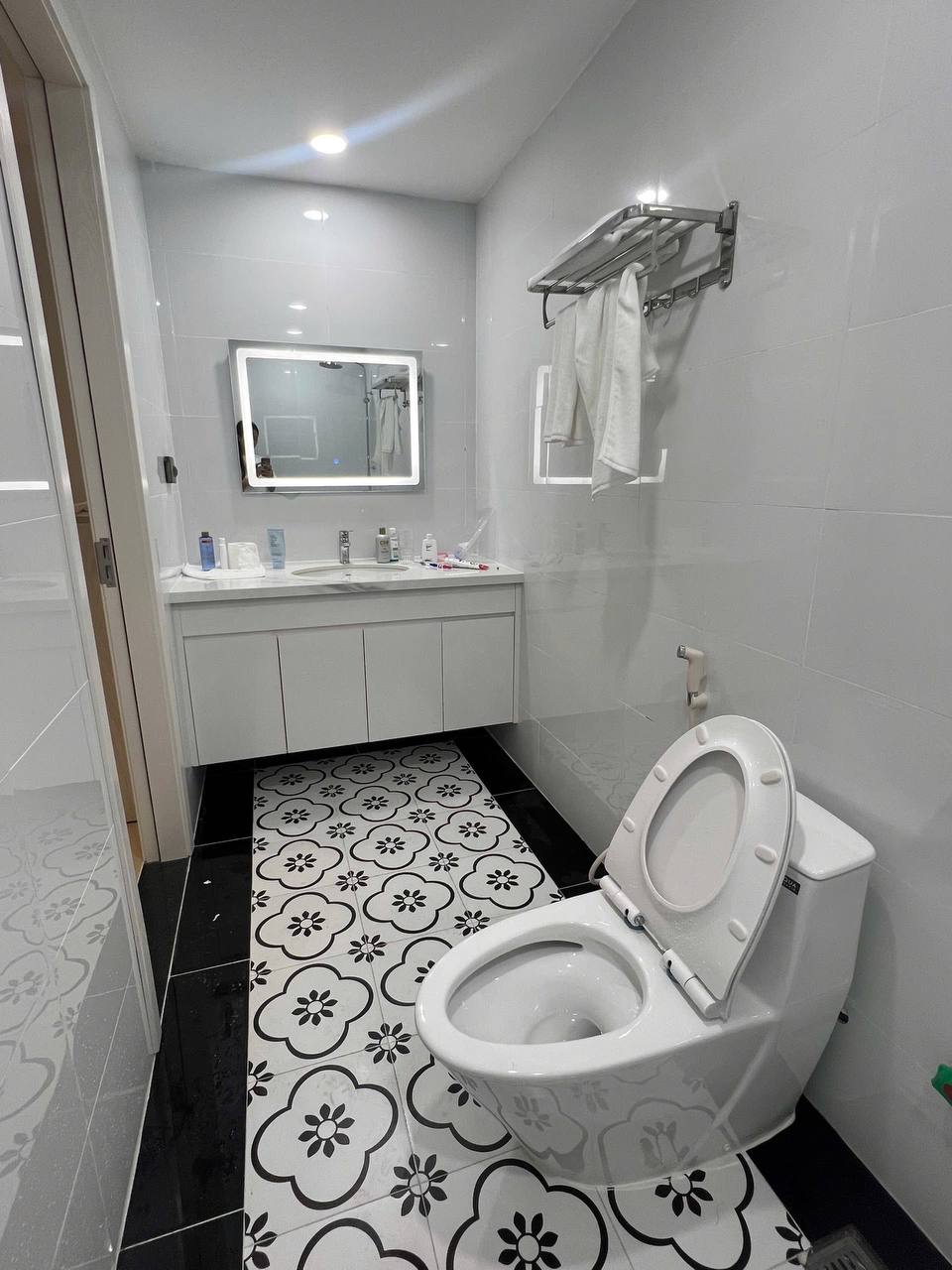 Phòng ngủ riêng căn 1BR - giường đôi, ga trắng, tủ gỗ sáng, tranh đen trắng