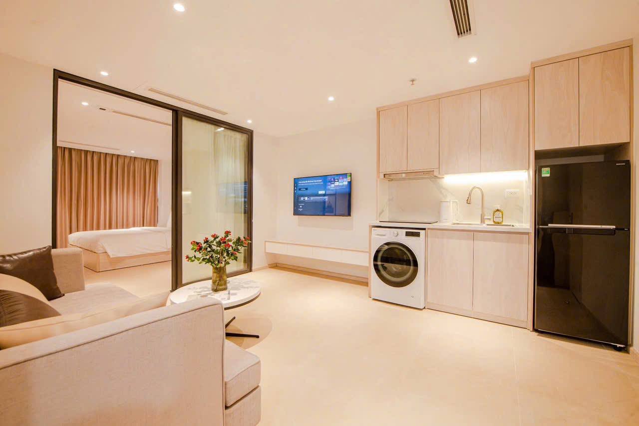 Tranh đen trắng châu Âu treo tường, giường gỗ sáng, ga trắng sọc, tone kem tổng thể